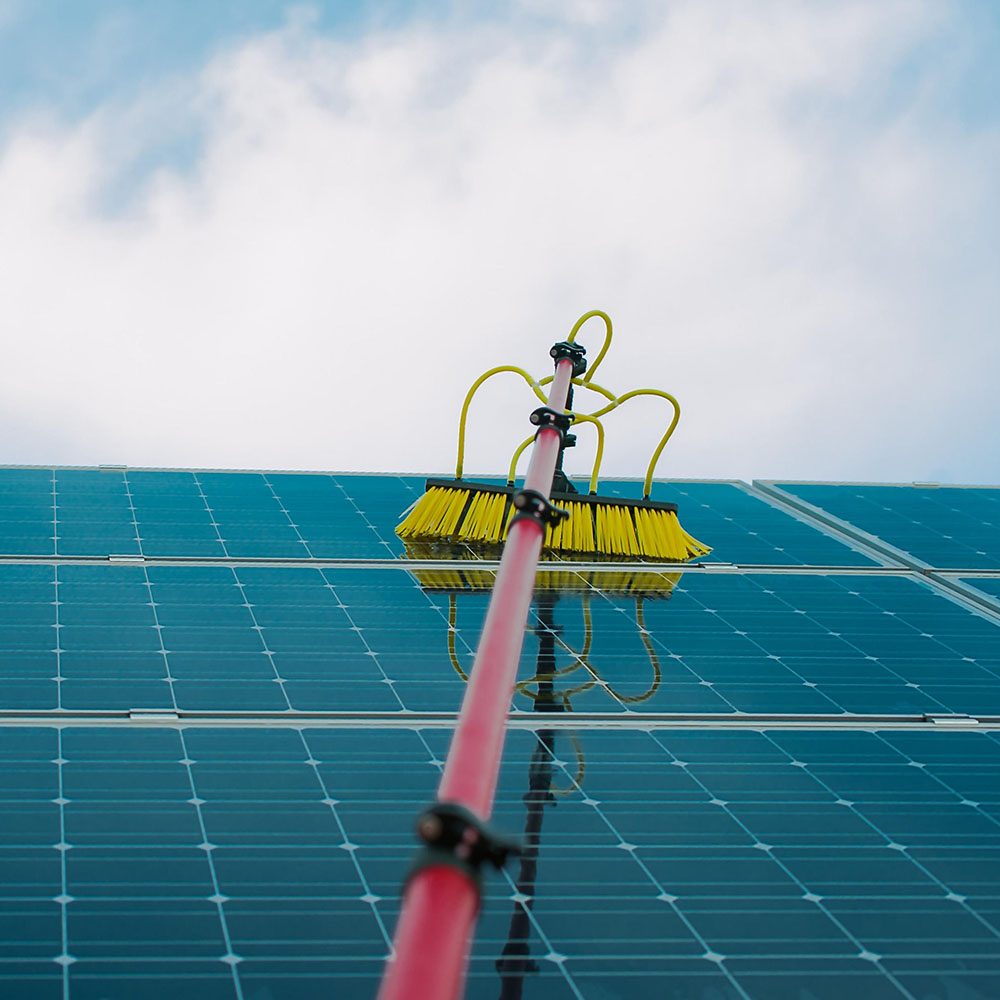 Solar panels being cleaned with a water-fed pole and soft brush in Shropshire